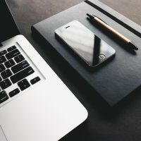 编辑部成员在办公桌前整理 www.kk动漫 作品档案与章节列表资料，桌上放着笔记本与便签，光线明亮